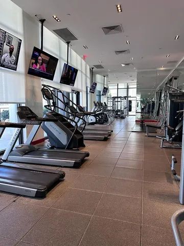 a living room with gym equipment and a flat screen tv