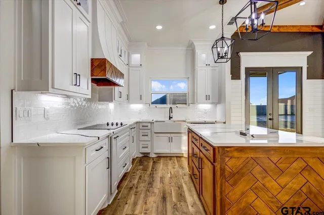 a kitchen with stainless steel appliances granite countertop a sink a stove and cabinets
