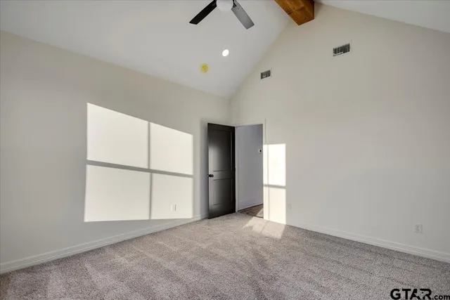 an empty room with windows and ceiling fan