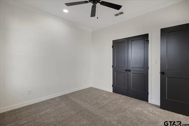an empty room with a ceiling fan and wooden floor