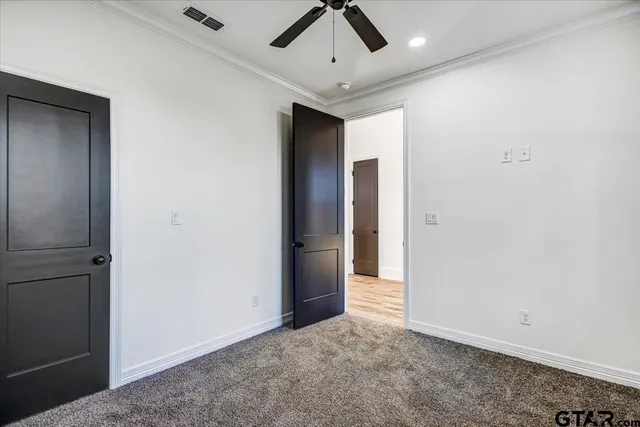 an empty room with chandelier fan