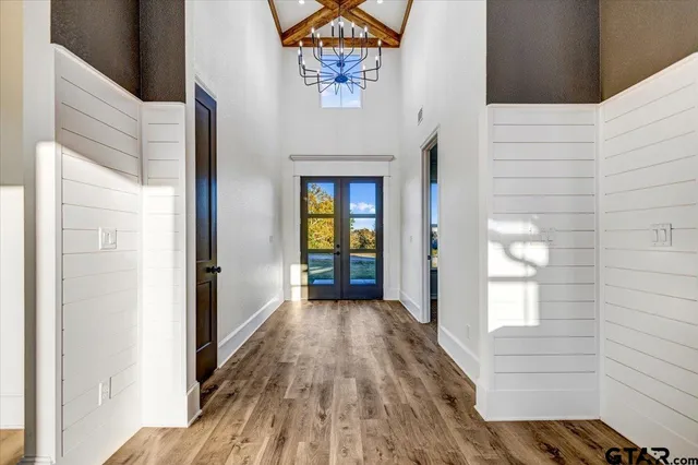a view of a hallway with wooden floor and a bathroom