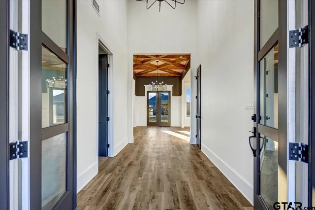 a view of a hallway with wooden floor and staircase