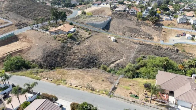an aerial view of a house with a yard and mountain view in back