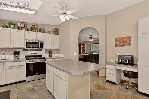 a kitchen with kitchen island a counter appliances and cabinets