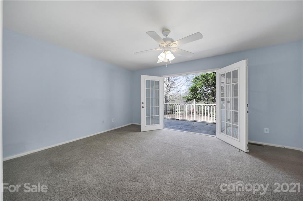 7032 Cambridge Circle Tega Cay, SC 29708 - Photo 18 of 36 a view of a big room with wooden floor a ceiling fan and windows