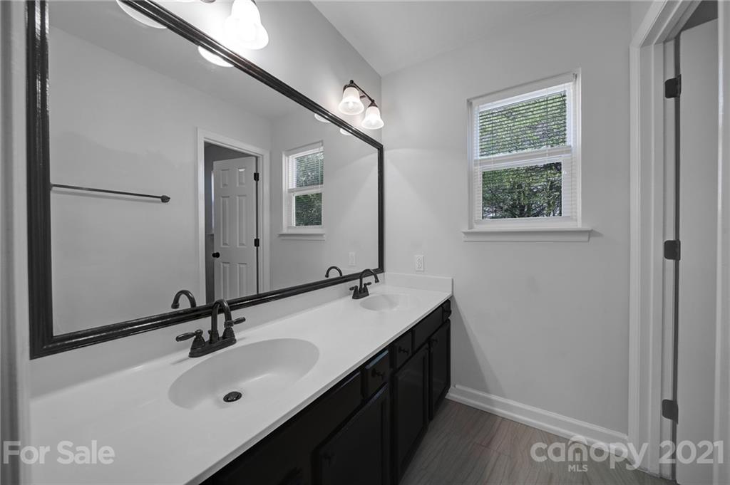7032 Cambridge Circle Tega Cay, SC 29708 - Photo 21 of 36 a bathroom with a double vanity sink and a mirror