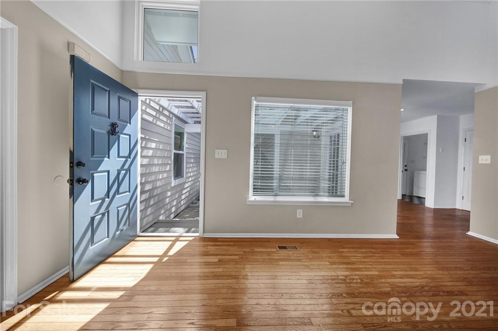 7032 Cambridge Circle Tega Cay, SC 29708 - Photo 4 of 36 a view of an empty room with wooden floor and a window