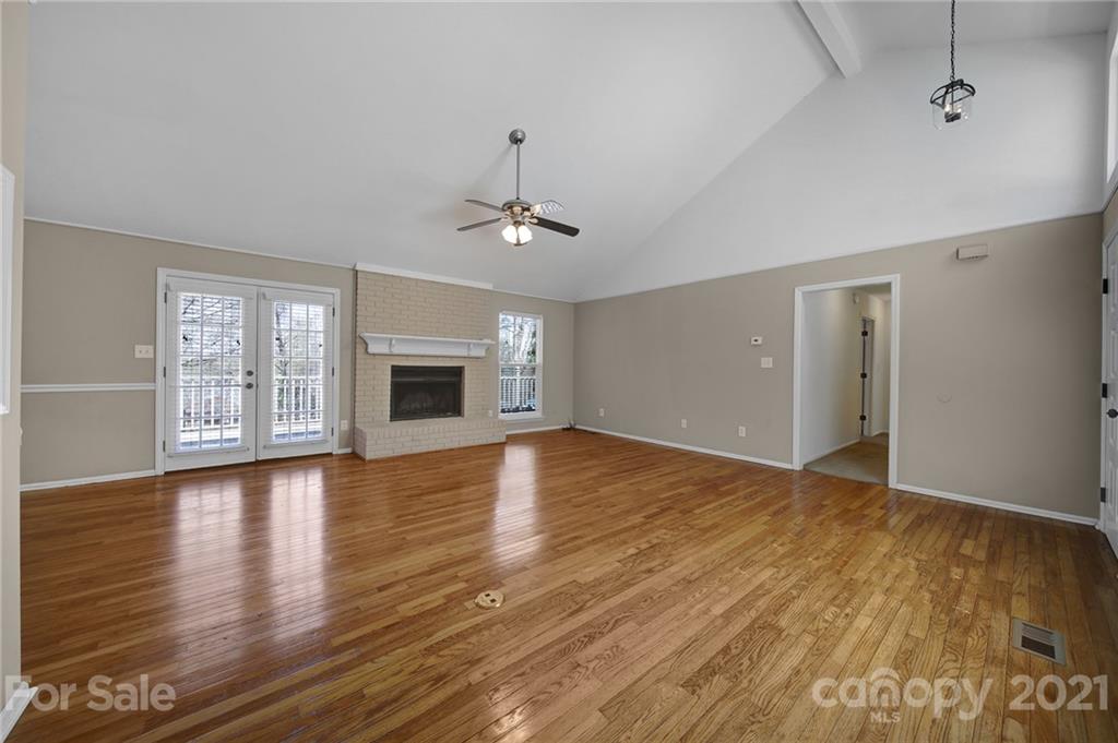 7032 Cambridge Circle Tega Cay, SC 29708 - Photo 7 of 36 a view of an empty room with wooden floor and a window