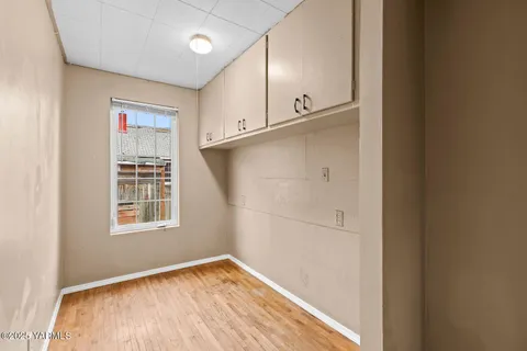 a view of empty room with wooden floor and fan