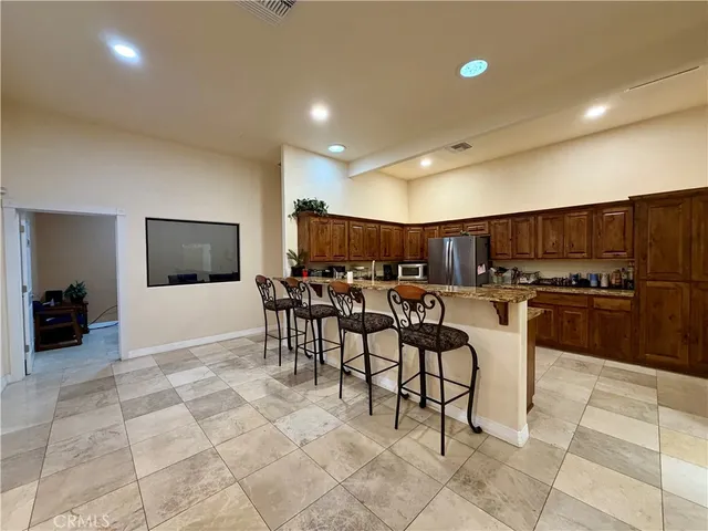a view of a kitchen with kitchen island a dining table and chairs