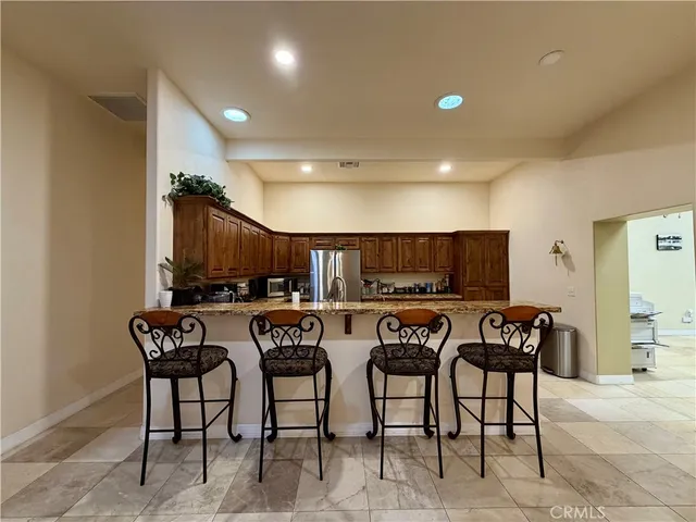 a kitchen with stainless steel appliances granite countertop a stove a sink dishwasher and a refrigerator