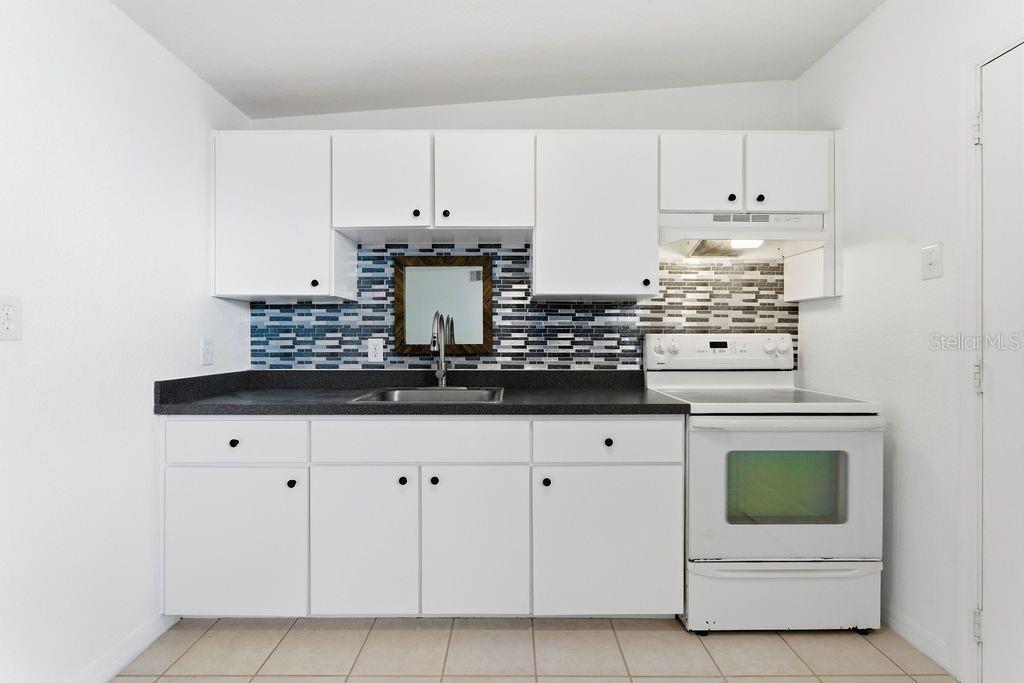 720 Southeast 3rd Street Ocala, FL 34471 - Photo 60 of 82 a kitchen with white cabinets and appliances