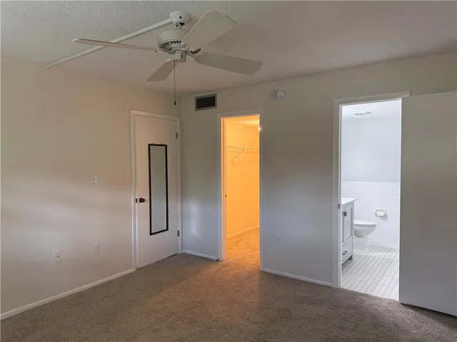 an empty room with a ceiling fan and a window