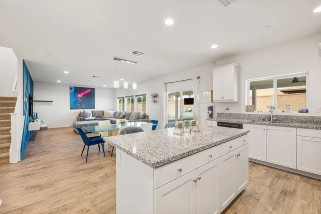 a kitchen with granite countertop a sink and a wooden floors