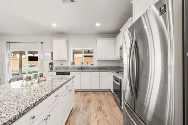 a kitchen with white cabinets and stainless steel appliances