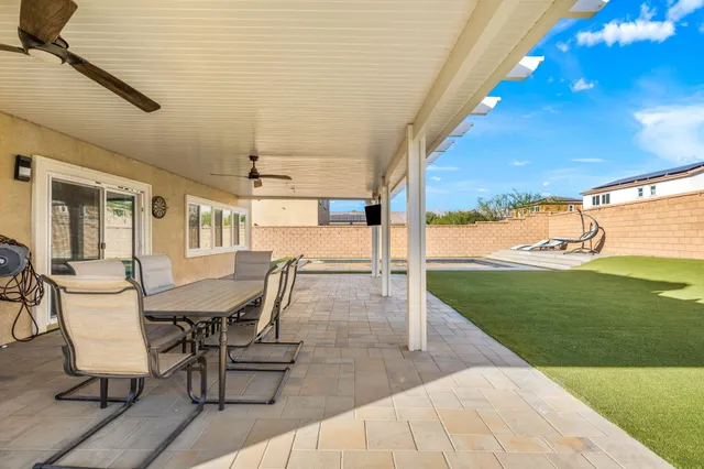 a view of a patio with a table chairs and a backyard