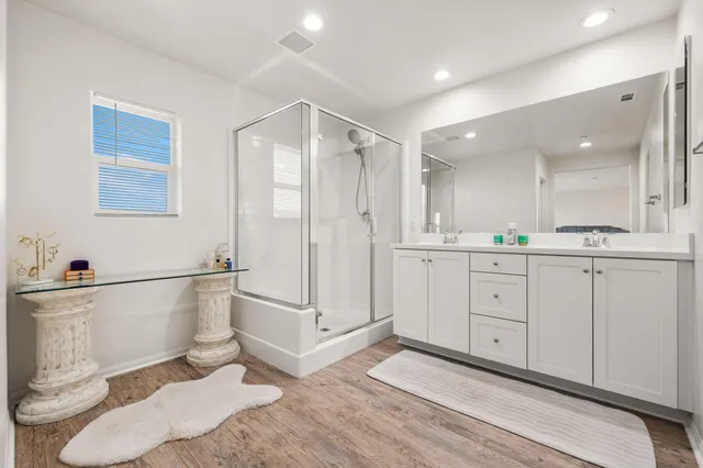 a bathroom with a shower sink and mirror