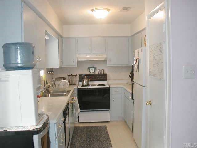 4319 Lake Ridge Drive, Unit 9B Raleigh, NC 27604 - Photo 8 of 10 a kitchen with a white stove top oven and refrigerator
