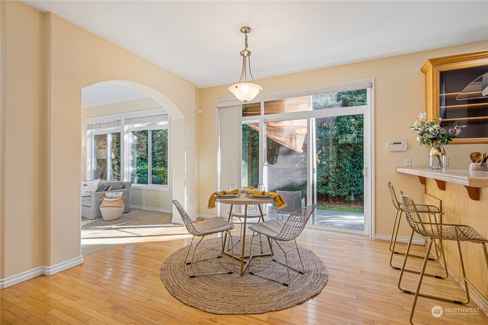 18529 33rd Avenue Southeast Bothell, WA 98012 - Photo 14 of 40 a dining room with wooden floor a chandelier a glass table and chairs