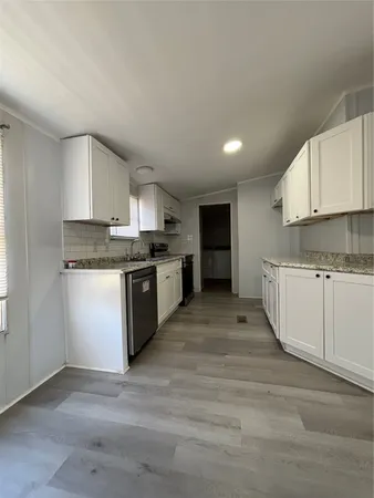 a kitchen with granite countertop a stove top oven sink and cabinets