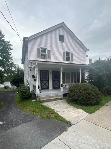 a front view of a house with garden and porch
