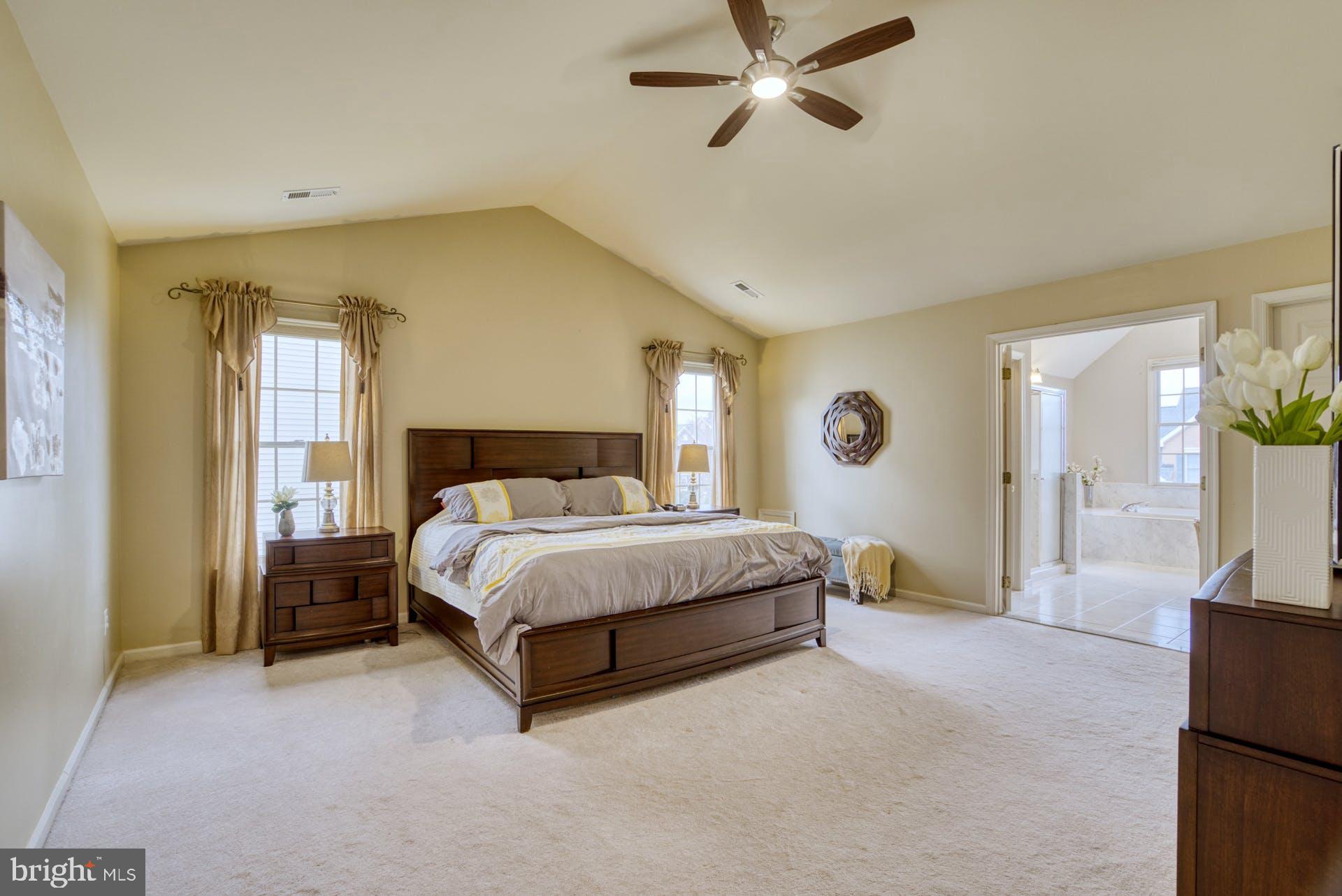 10855 Hunter Gate Way Reston, VA 20194 - Photo 20 of 57 a spacious bedroom with a bed and a chandelier
