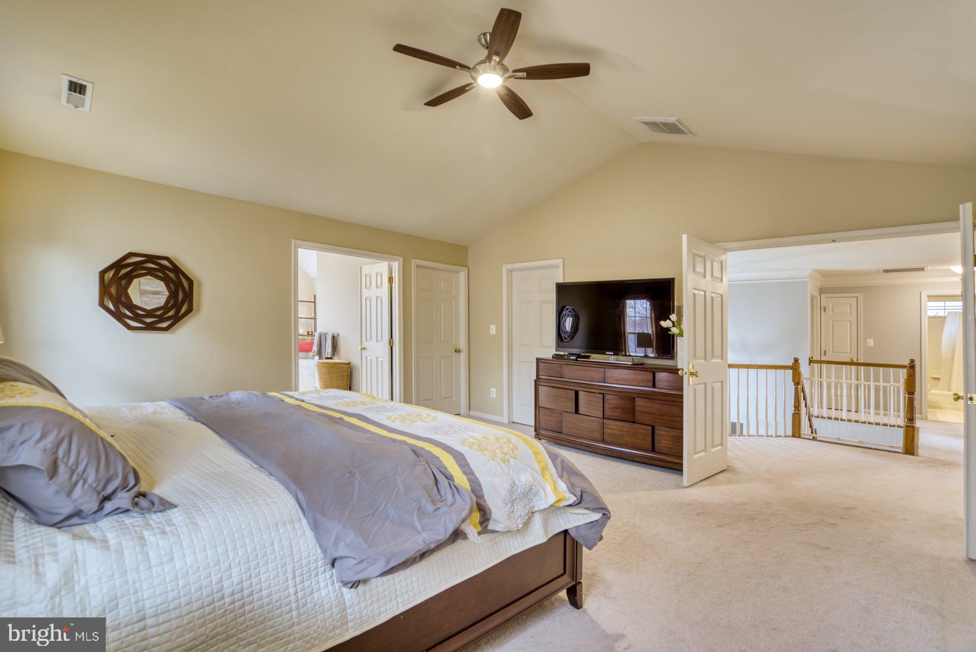10855 Hunter Gate Way Reston, VA 20194 - Photo 21 of 57 a bedroom with a large bed and a flat screen tv