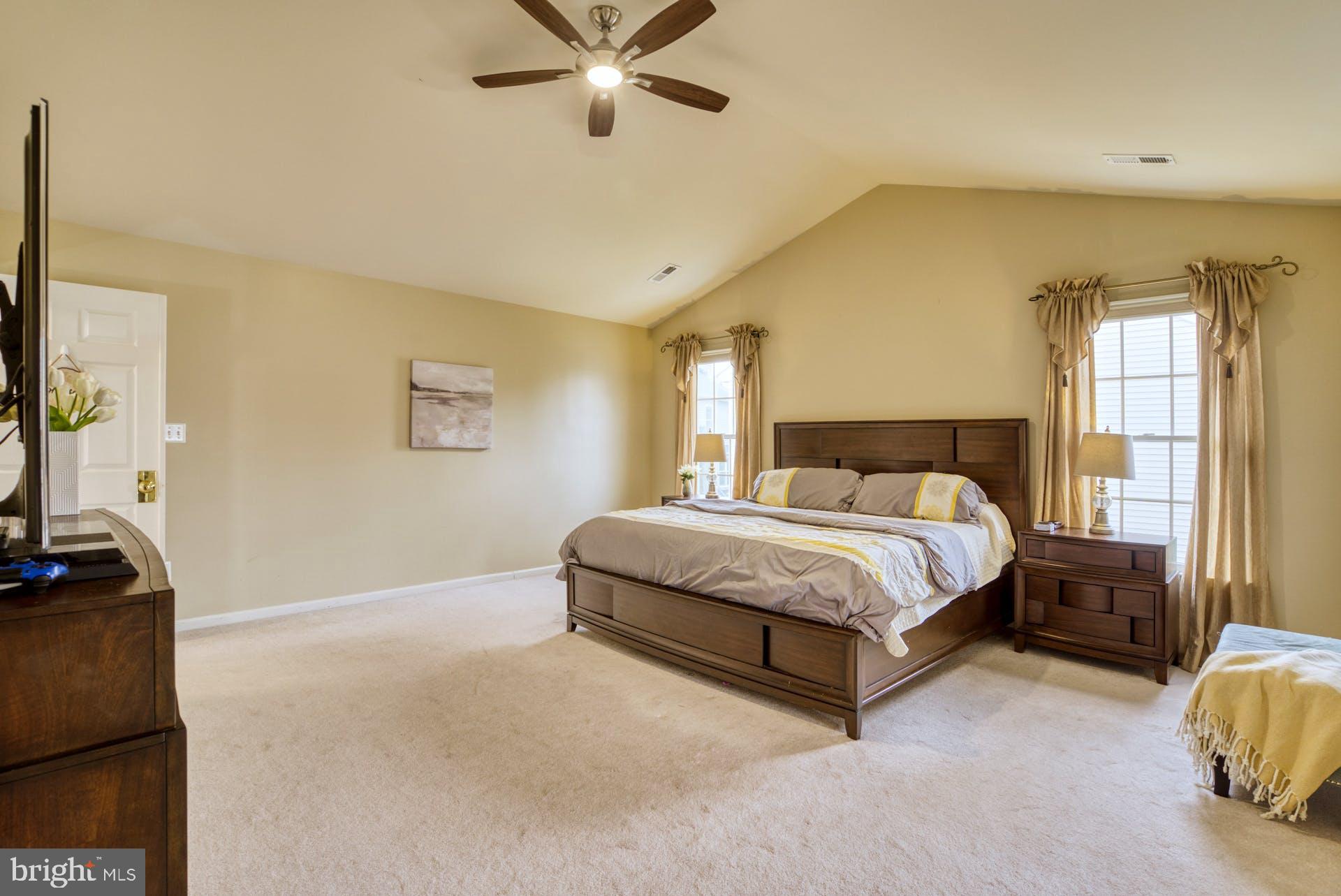 10855 Hunter Gate Way Reston, VA 20194 - Photo 22 of 57 a spacious bedroom with a bed and a flat screen tv