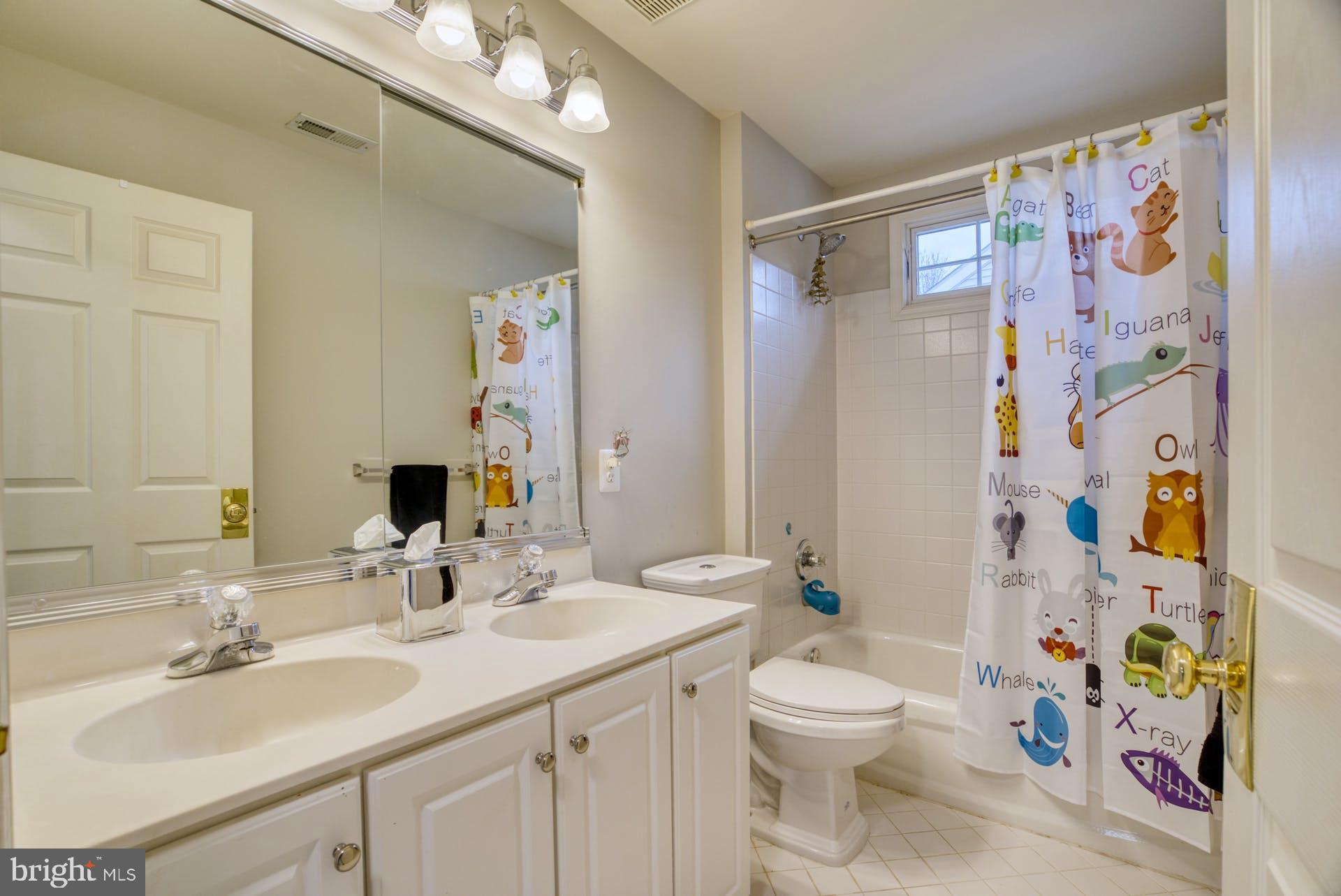 10855 Hunter Gate Way Reston, VA 20194 - Photo 30 of 57 a bathroom with a sink a toilet and shower curtain