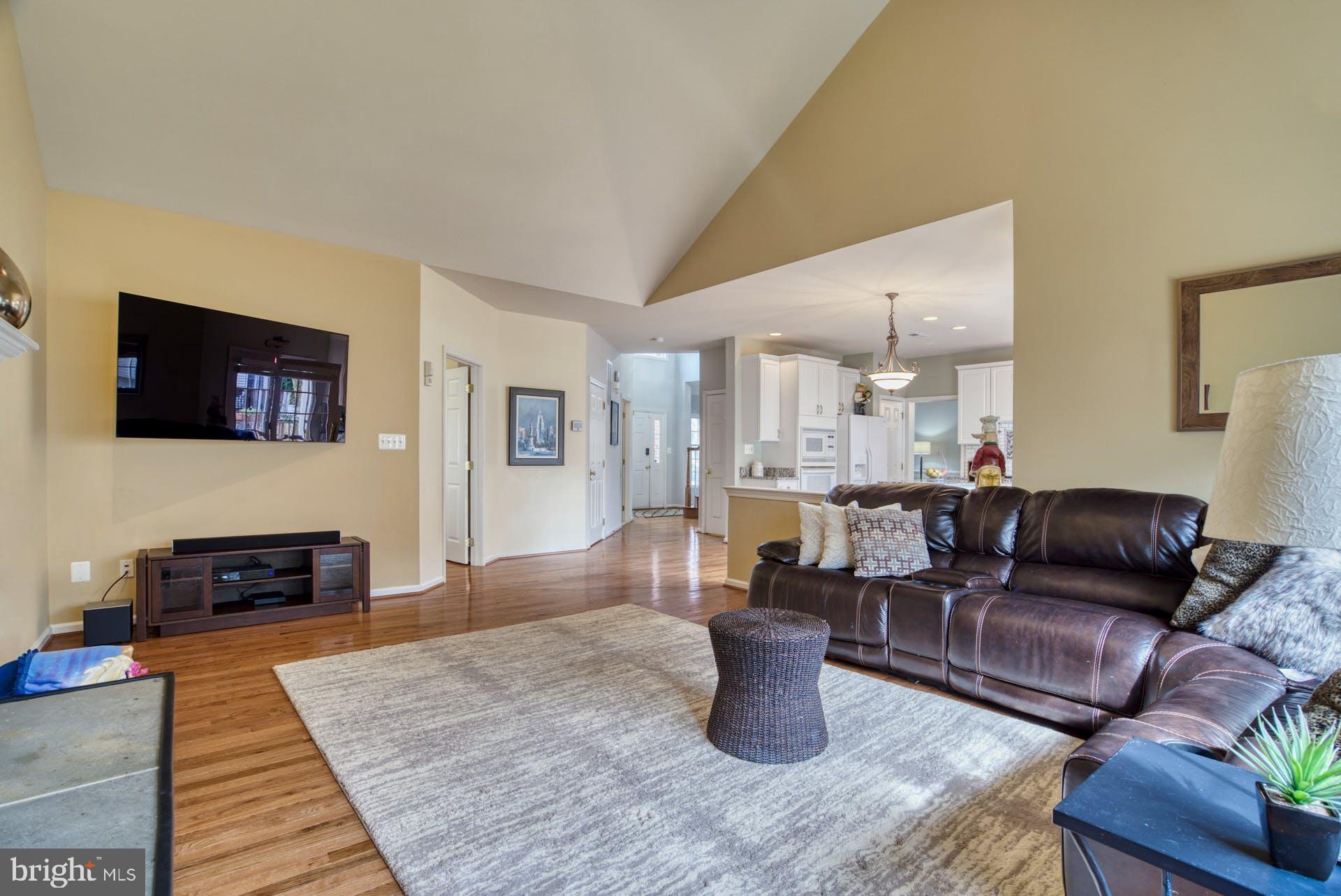 10855 Hunter Gate Way Reston, VA 20194 - Photo 5 of 57 a living room with furniture a flat screen tv and kitchen view