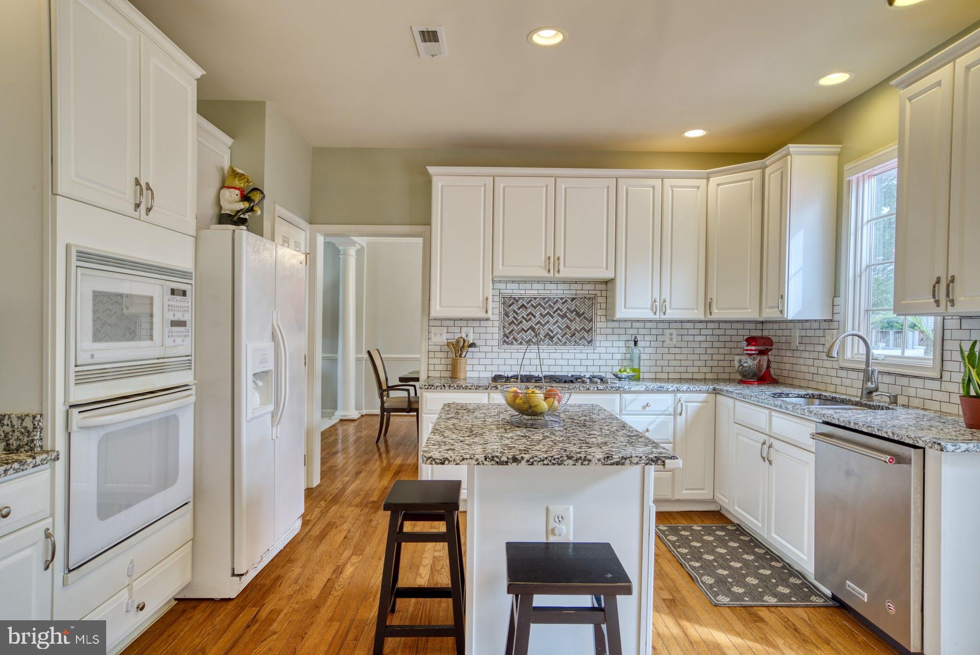 10855 Hunter Gate Way Reston, VA 20194 - Photo 8 of 57 a kitchen with a table chairs refrigerator and cabinets