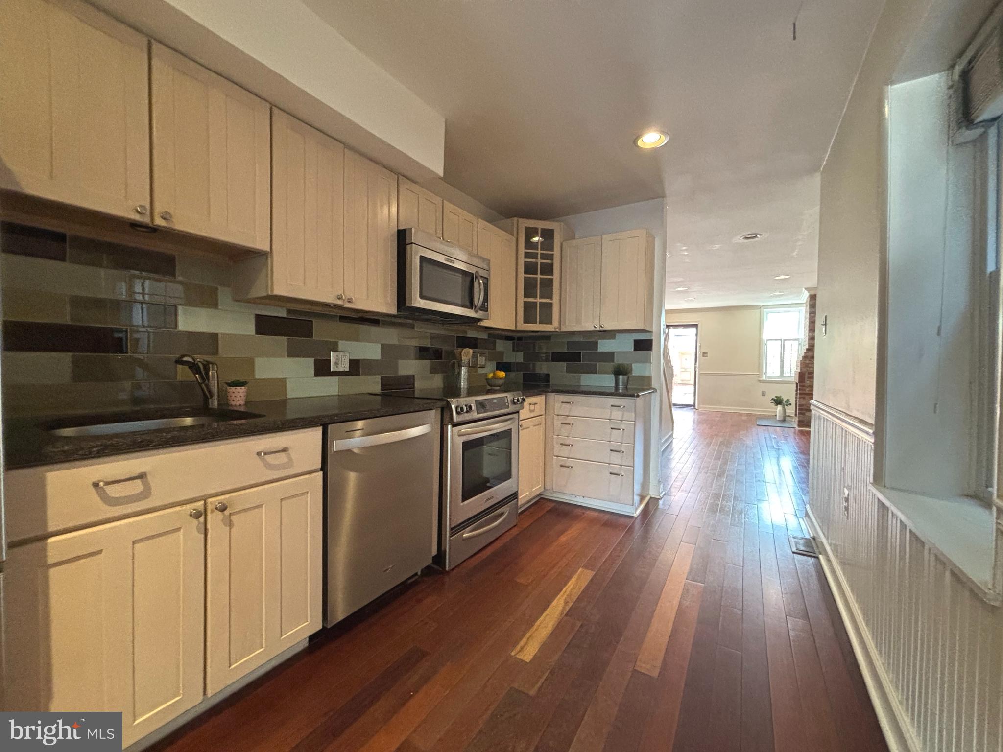 1218 Riverside Avenue Baltimore, MD 21230 - Photo 11 of 38 a kitchen with stainless steel appliances white cabinets a sink a stove a refrigerator and white cabinets