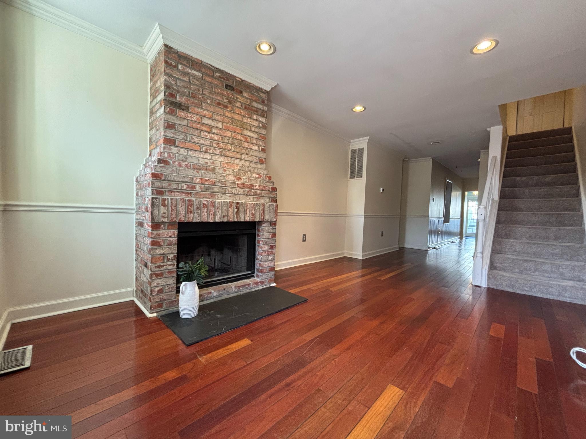 1218 Riverside Avenue Baltimore, MD 21230 - Photo 6 of 38 an empty room with wooden floor fireplace and windows