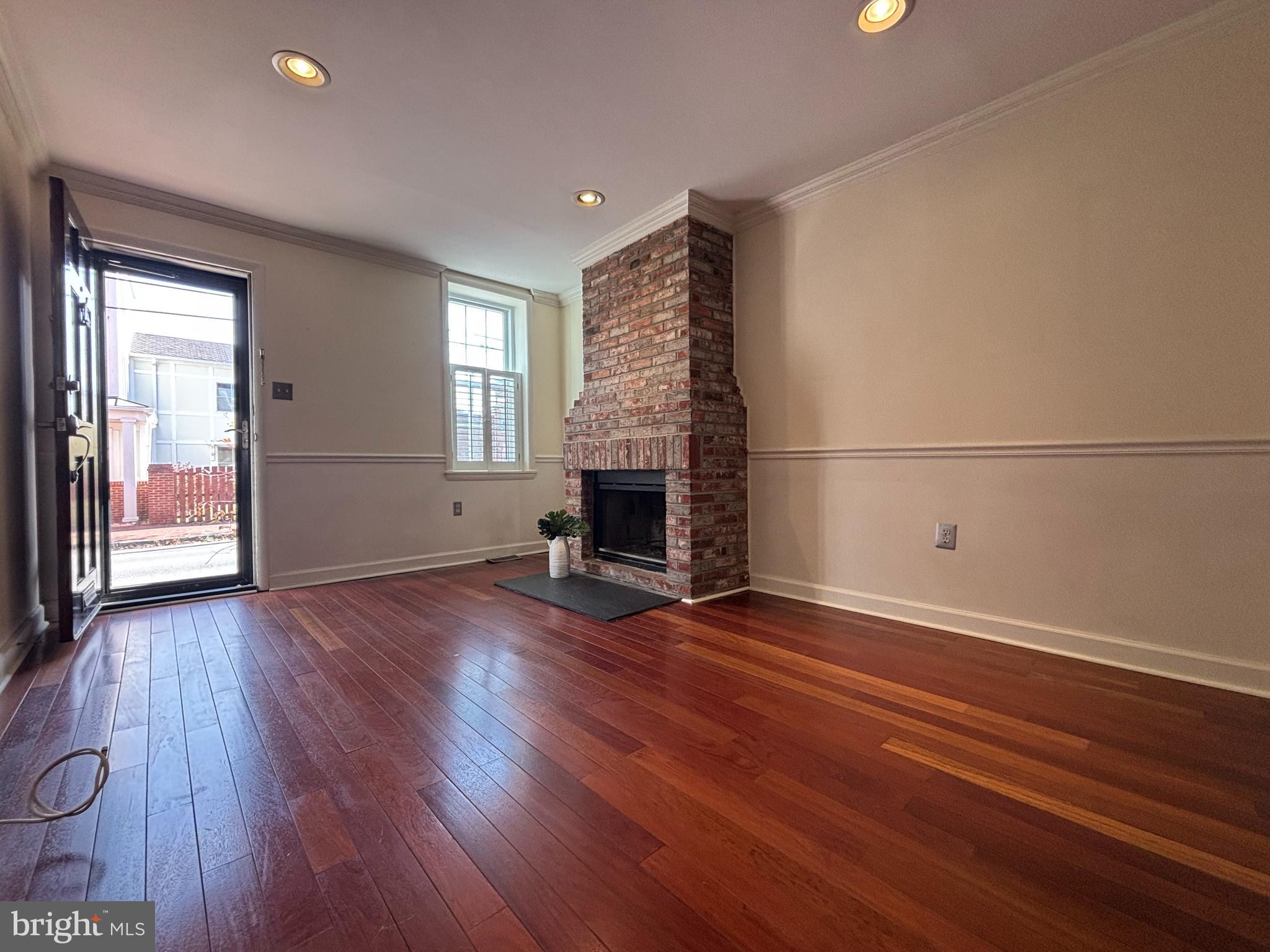 1218 Riverside Avenue Baltimore, MD 21230 - Photo 7 of 38 an empty room with wooden floor fireplace and windows