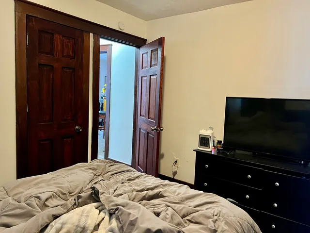 a bedroom with a bed and a flat screen tv
