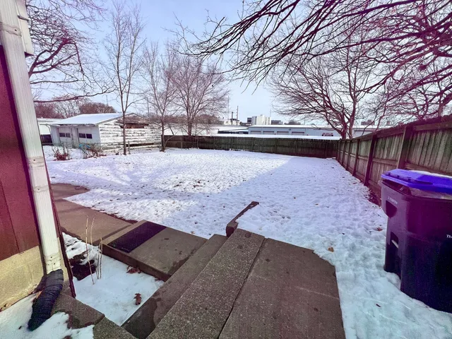 a front view of a house with a yard covered in snow