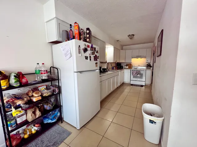 a kitchen with stainless steel appliances a sink dishwasher stove refrigerator and cabinets