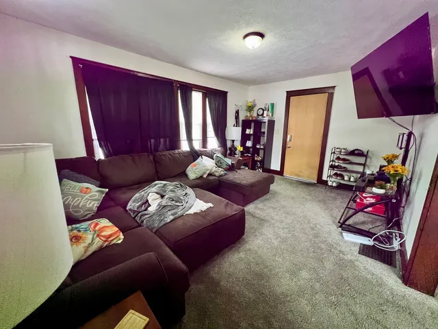 a living room with furniture a bed and gym equipment