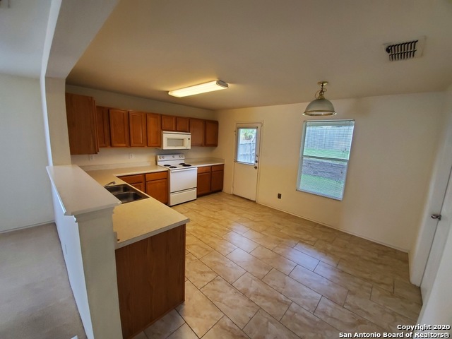 25714 Gold Yarrow San Antonio, TX 78260 - Photo 6 of 15 a kitchen with stainless steel appliances a stove top oven a sink dishwasher and a refrigerator