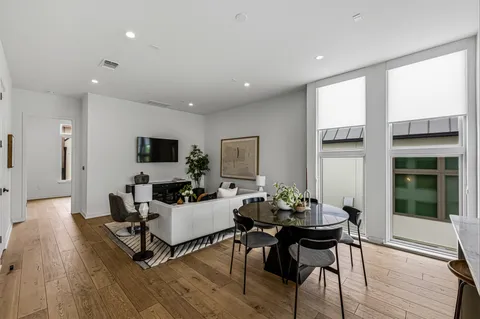 a living room with furniture a flat screen tv and a large window