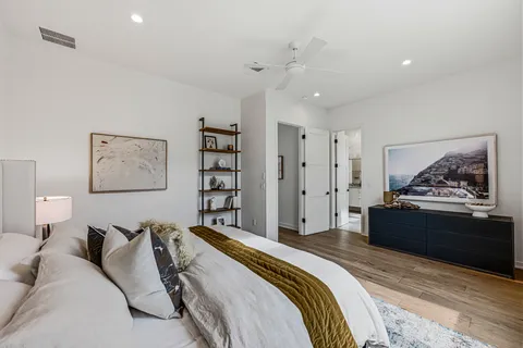 a spacious bedroom with a bed and cabinet