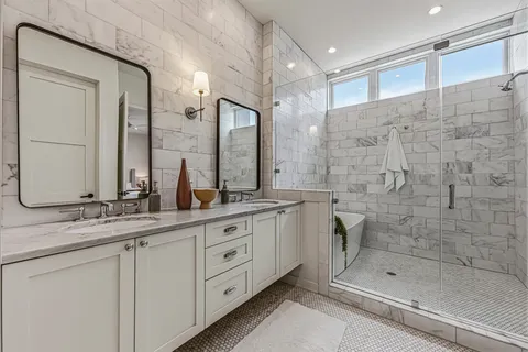 a bathroom with a double vanity sink mirror and shower