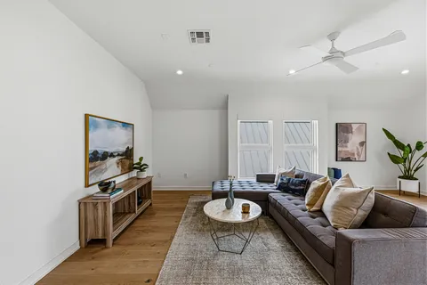 a living room with furniture and a wooden floor