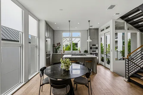 a kitchen with stainless steel appliances granite countertop a stove a refrigerator and a dining table