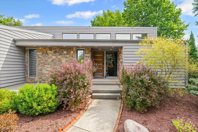 a kitchen with a stove a sink dishwasher a dining table and chairs with wooden floor