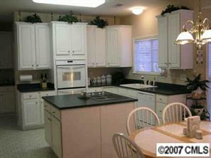 4118 Desert Rose Court Fort Mill, SC 29708 - Photo 4 of 8 a kitchen with granite countertop a sink a stove a dining table and chairs