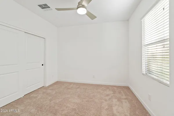an empty room with closet and windows