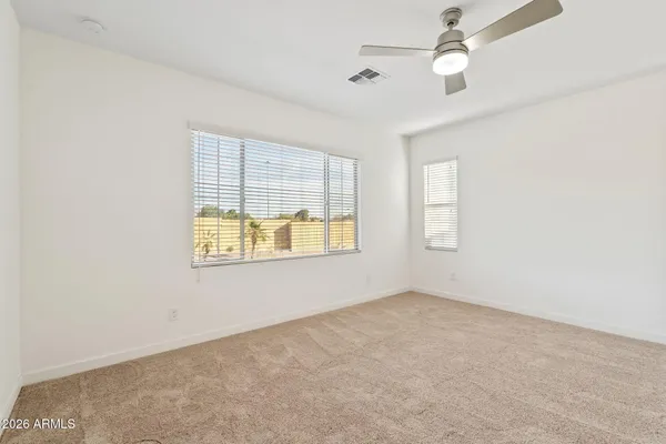 an empty room with a window and a ceiling fan