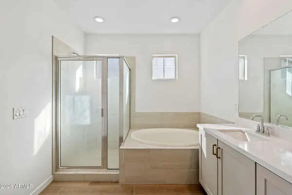 a bathroom with a tub sink and mirror